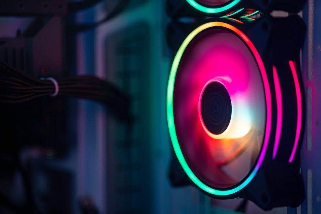 pexels-photo-30830246 Close-up of a colorful RGB cooling fan in a gaming PC setup.